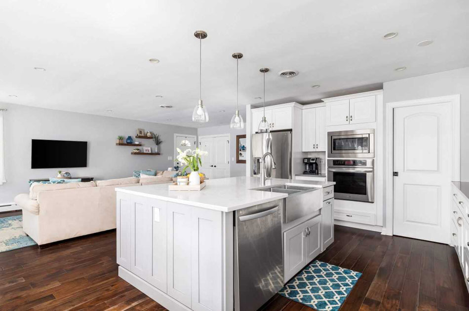 Stacked double wall ovens built into a white cabinet run