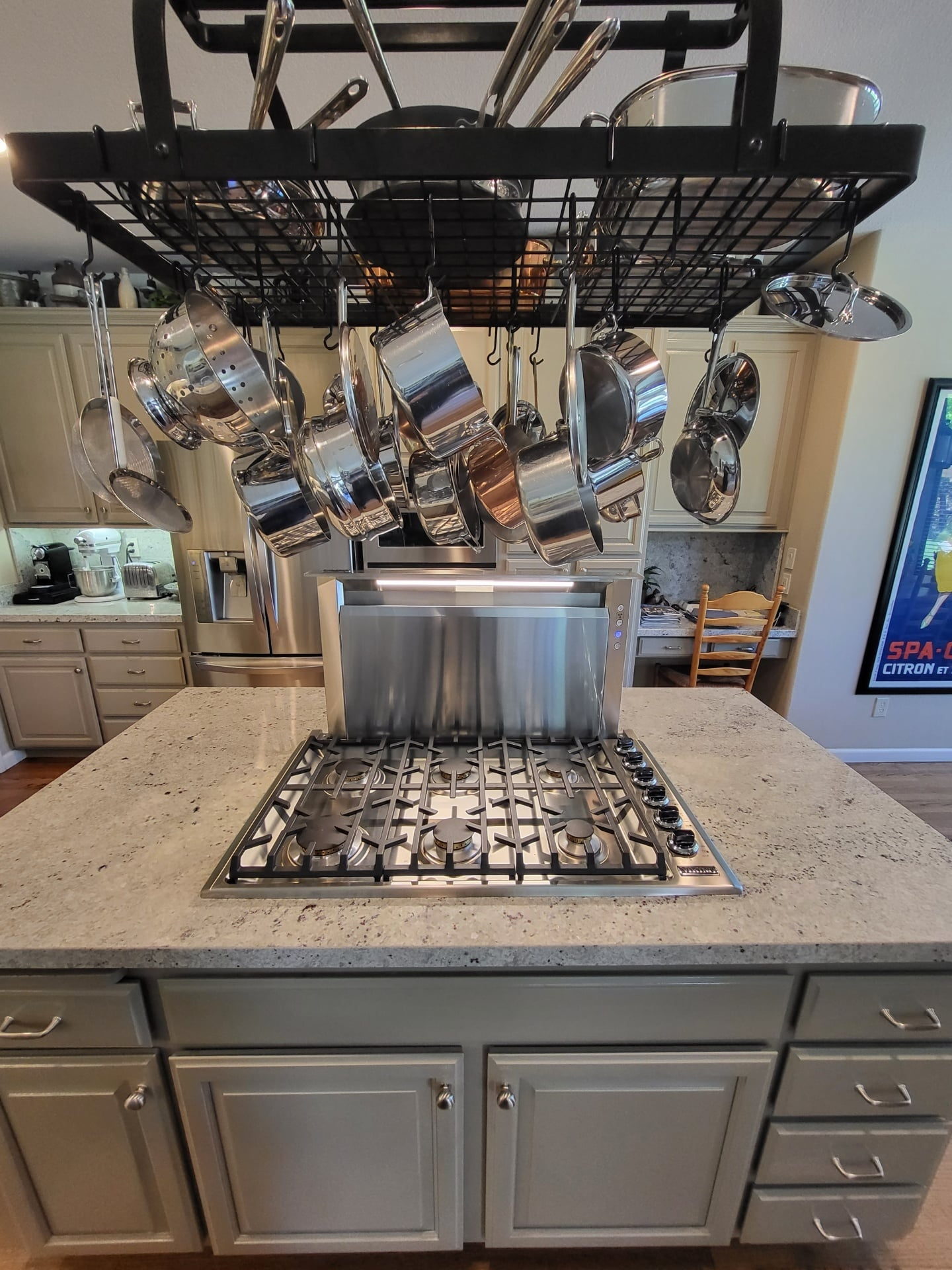 Gas cooktop set into a stone island with a downdraft vent